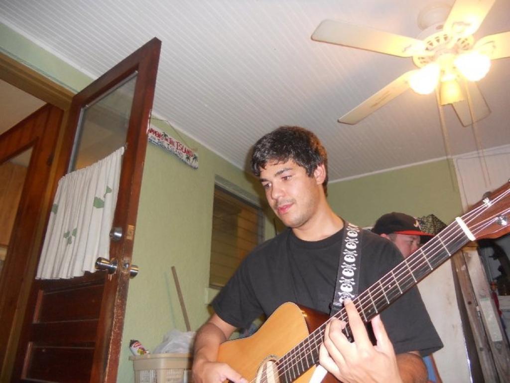 Victor playing the guitar in college in his room