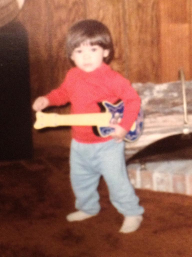 Victor as a toddler with a guitar