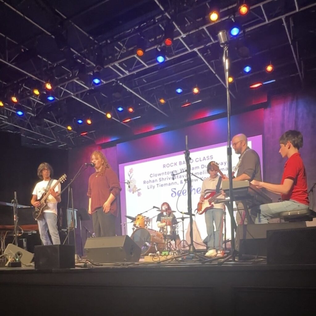 The Rock Band Class performs on stage at the Spring Showcase