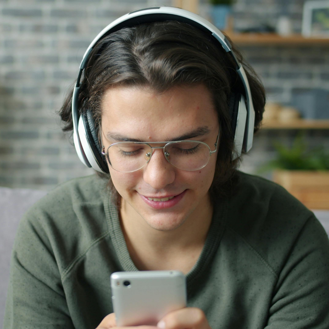 teen boy listens to music from his device with headphones on