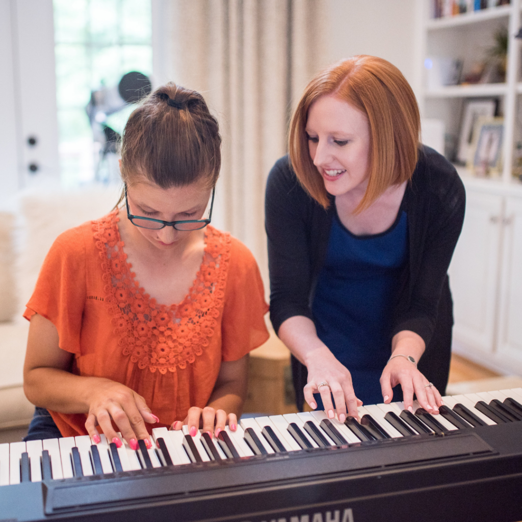 MMM music therapist works wih a student on piano