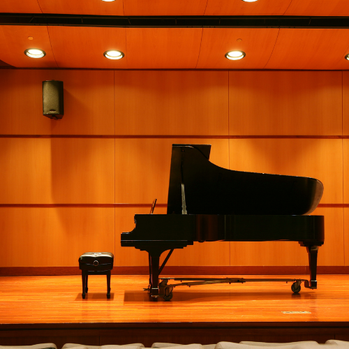 piano and bench on an empty stage